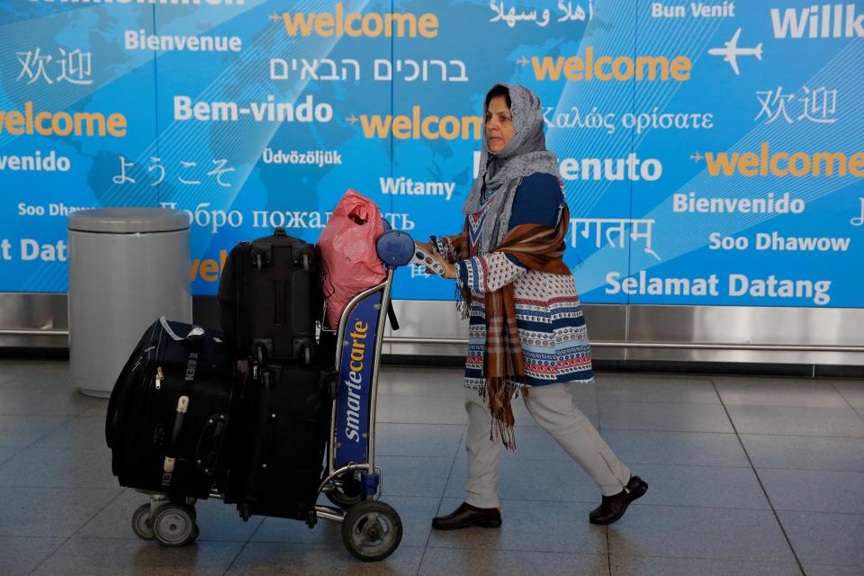 A woman exits immigration after arriving in New York from Dubai