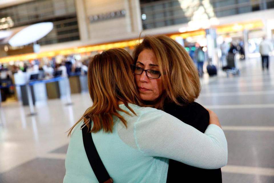 Homa Homaei, a US citizen from Iran, is hugged by a lawyer working to help her family members 