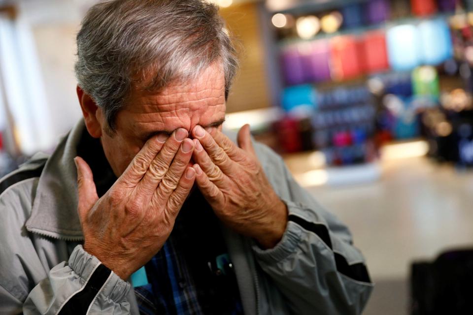 Hossein Khoshbakhty wipes tears from his eyes while speaking about his Iranian brother who is affected by the ban 