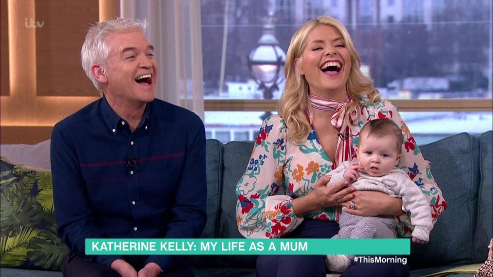  Holly beamed with delight as she clutched little Rose, aged just three months