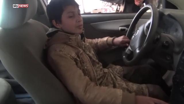  The young boy is later pictured at the wheel of a car where he sings a song in praise of ISIS jihadists