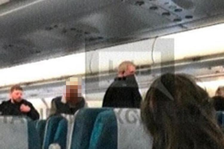  A picture from on board the plane shows cops walking through the aisle