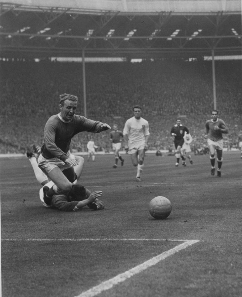 Young falls to the ground after a challenge by Wednesday keeper Ron Springett in the 1966 FA Cup final