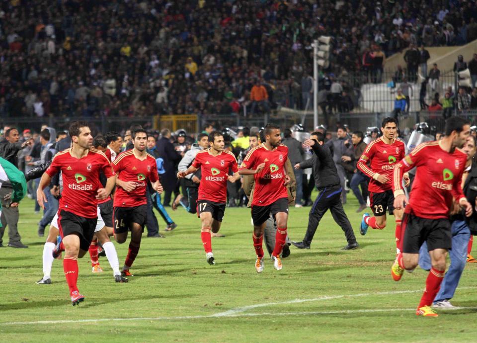  Al-Ahly players run for safety during clashes