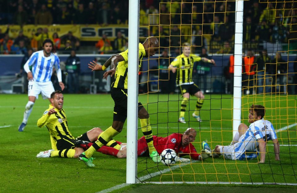 Malaga players look on in desperation as Carlos Santana pokes home for Dortmund