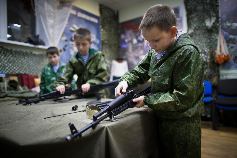  Yunarmia recruit Alexander Yadryshnikov, ten, and his friends take apart Kalashnikov rifles as part of training near Yekaterinburg