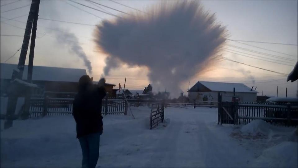 A young man throws boiling water into the air, within one second it has turned to snow 