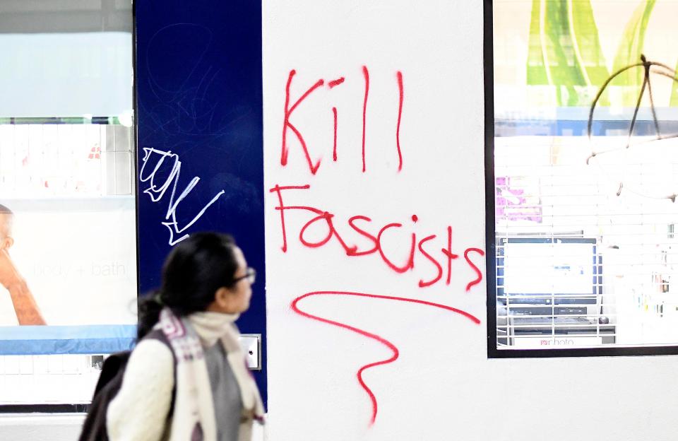  A woman passes graffiti written by protesters against Breitbart News editor Milo Yiannopoulos