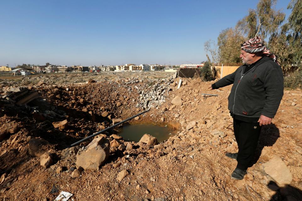  A man stands next to a hole by mortar shell at Nour Park, one is believed to have led to some animals escaping when it struck a cage