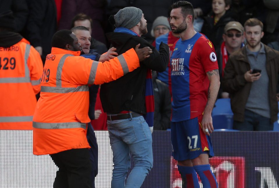 A Palace fan is restrained as he confronts Damien Delaney