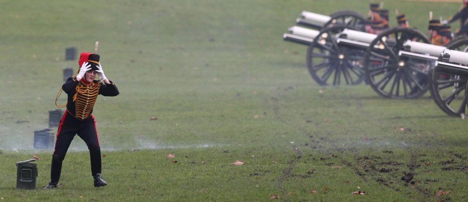  A member of the King's Troop Royal Horse Artillery clutches on to her hat during a 41-gun salute to commemorate the Queen's Sapphire Jubilee