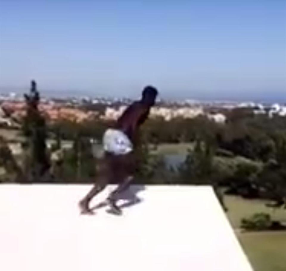 M'Baye Niang takes run up before jumping off roof into swimming pool below