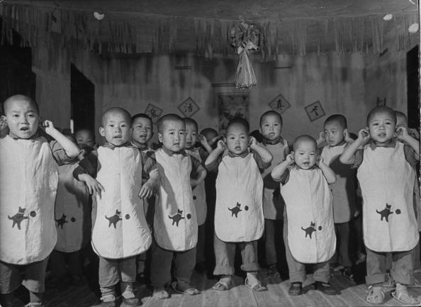  1941: Wartime Chinese orphans stand with their hands over their ears as they sing a bombing song, Oom, Oom, Oom (the sound of the planes)