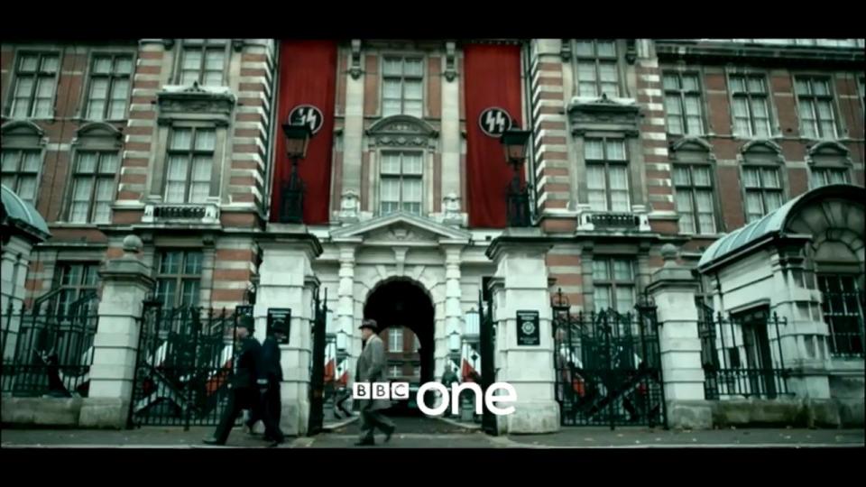 An imposing building in London is flanked by swastika drapes