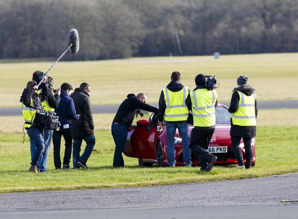  The team rushed round the car on the grass