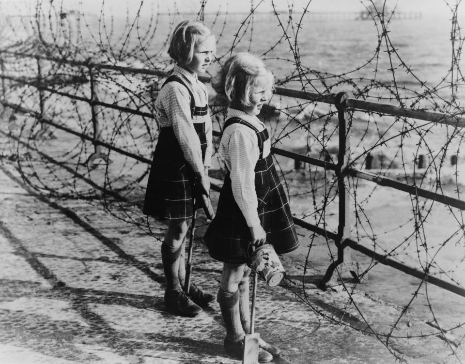  Two girls watch out across the English Channel through Britain's flimsy defensive system