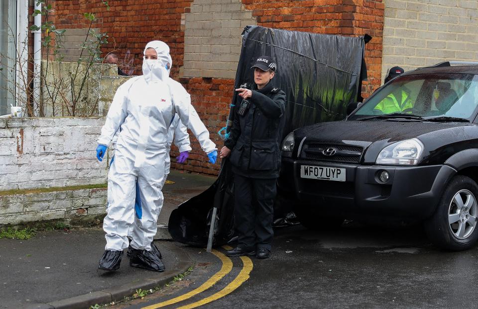 Forensic officers leave the scene through a fenced off alleyway on Graham Street close to excavation work at two properties on Broad Street, Swindon