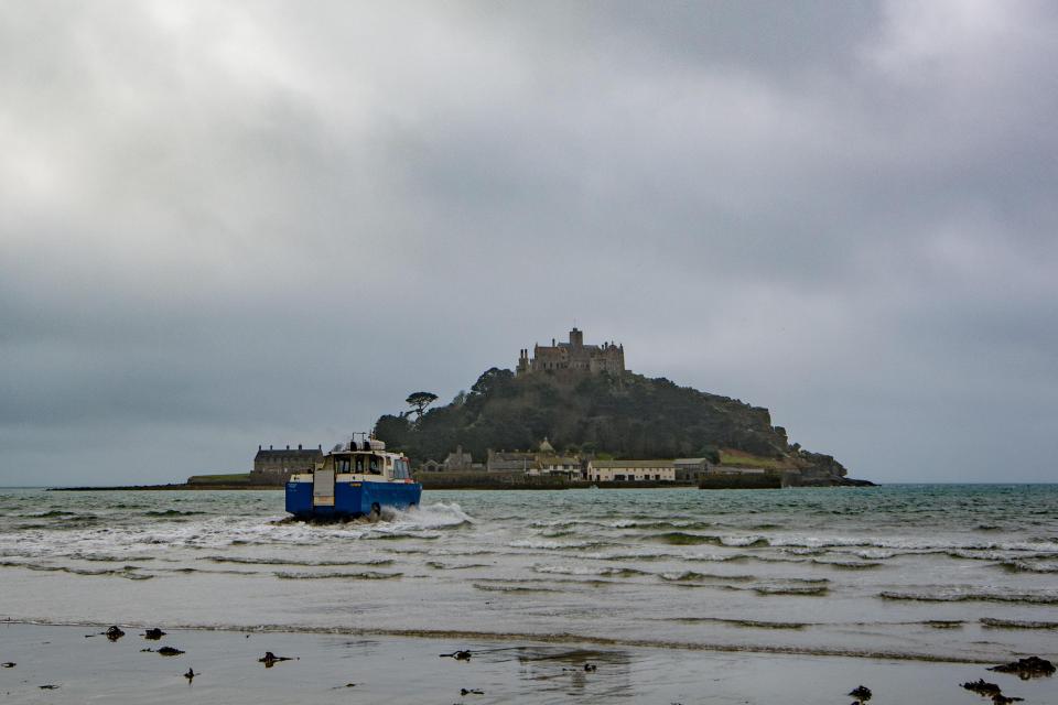  The grey skies loom overhead as an amphibious vehicle takes half term visitors to St Michaels Mount from Marazion in Cornwall