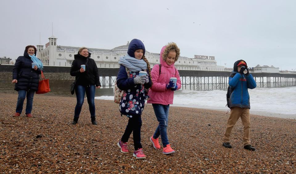  A family walk along the beach in Brighton, East Sussex, as the unsettled weather begins