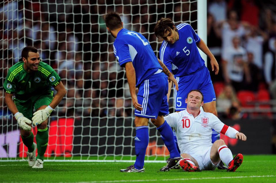 Wayne Rooney is helped up by San Marino defenders during England clash