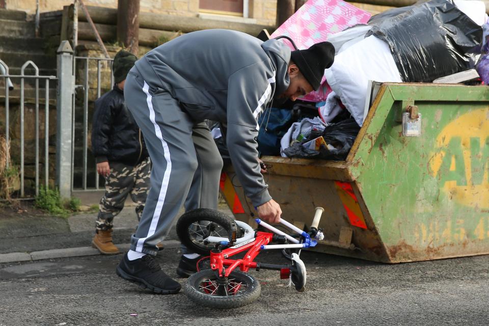 One man inspects a bike close to a skip near Bev's old house in Shipley, West Yorkshire