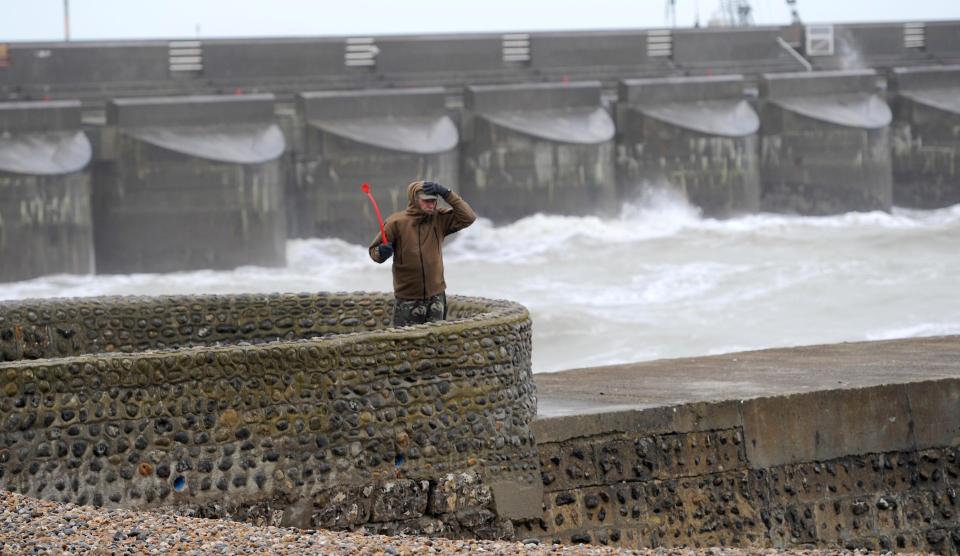  One walker has to hold on to his hat as the strong winds cause treacherous conditions in Brighton