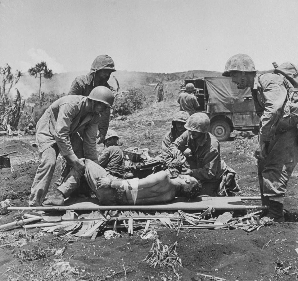  1944: US Marines tending to wounded comrades while the fighting rages on during the battle to take Saipan from the Japanese