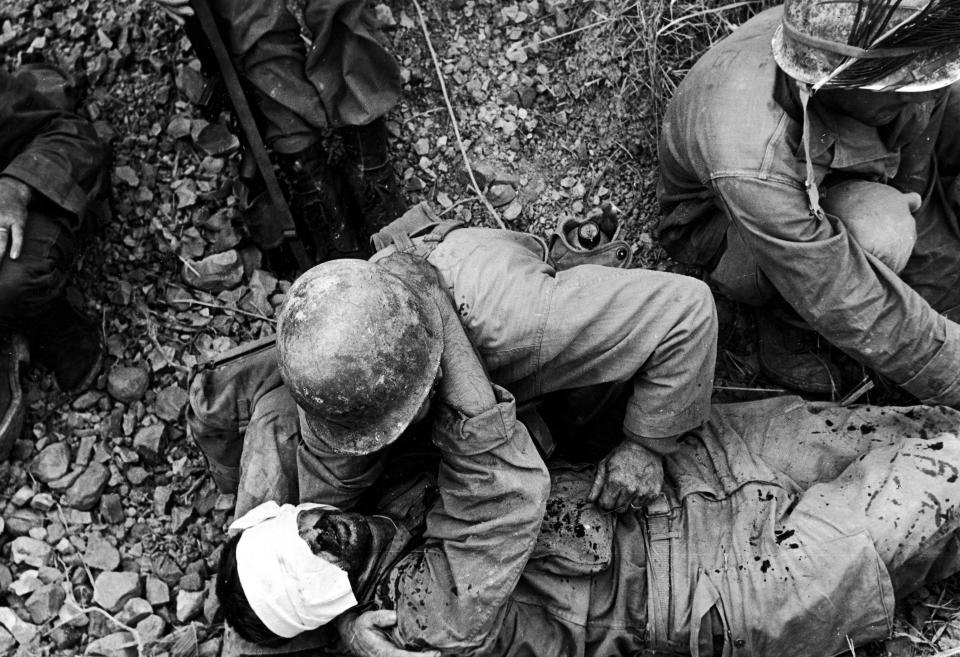  A soldier from the US 7th Army Division comforts a wounded comrade during the fight for Okinawa