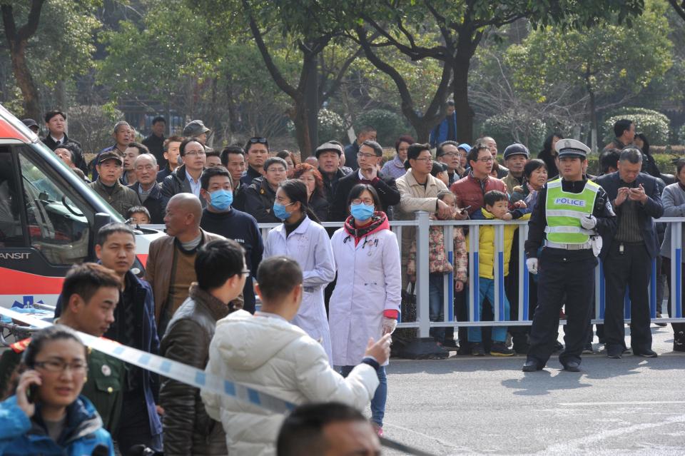  Stunned people look on as emergency workers battle the flames