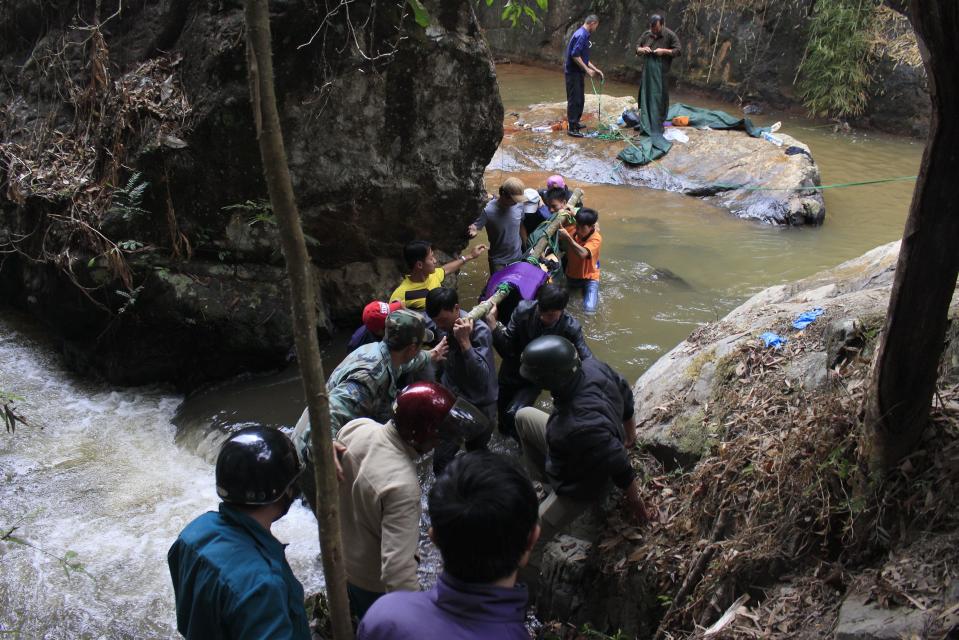 Rescuers carry one of three bodies of British tourists near a waterfall on the outskirts of the central highland town of Dalat on February 26, 2016