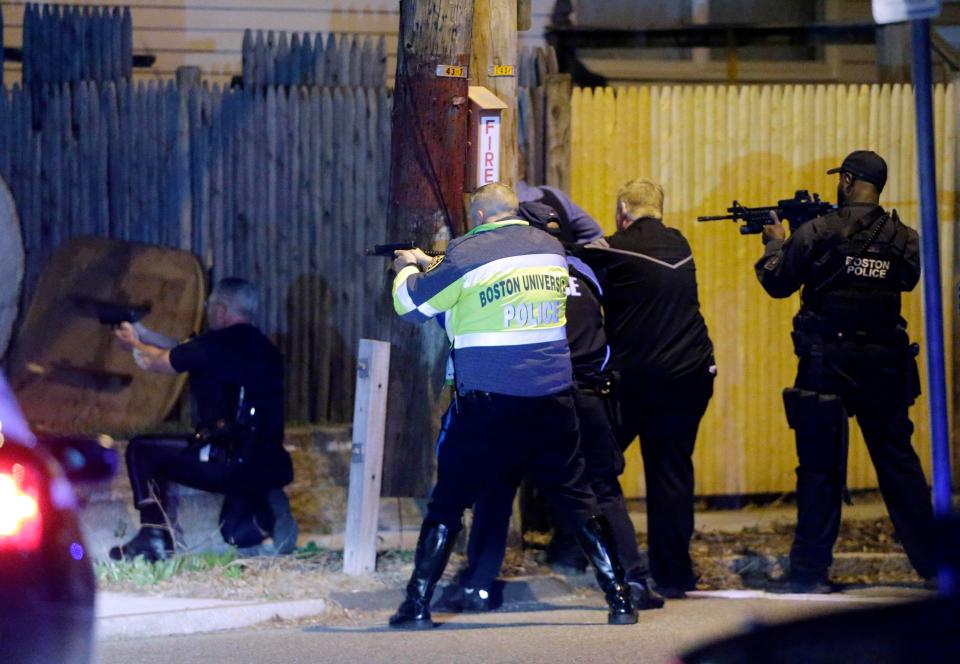  Police officers aim their weapons during the hunt for the Boston Marathon bombing suspects in Watertown