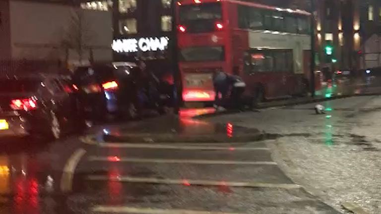  Footage filmed from inside a car shows two men bending down to help the floored moped rider