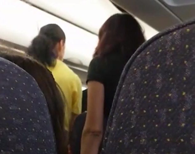 The feuding 'lawyer' finally gets out of her seat and moves to the other end of the plane