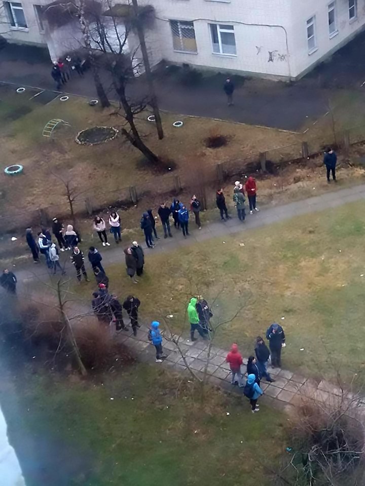 A crowd gathered below the building while the boy lingered at the edge