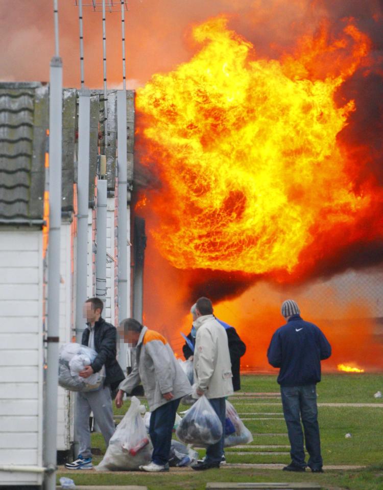  Inmates evacuate their accommodation blocks after a fire breaks out in HMP Ford in West Sussex