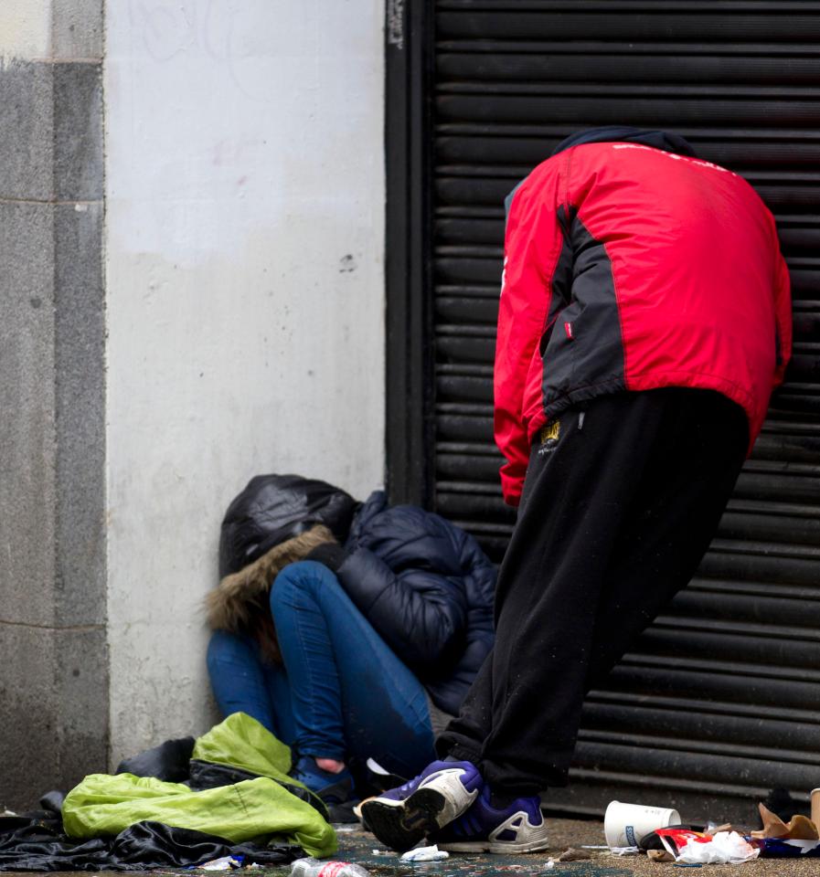 Drugs users slumped on a street corner after taking Spice