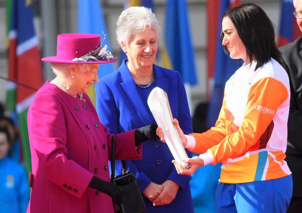  Her Majesty hands the baton to champion cyclist Anna Meares in a ceremony outside Buckingham Palace