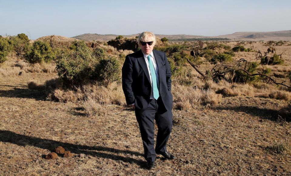  Poser: Mr Johnson stops for a pic with the elephants - looking out of place in his dark suit