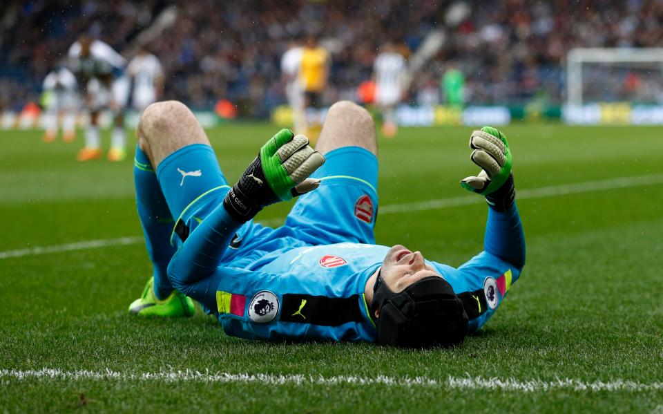 Petr Cech lies flat out on his back having hurt himself kicking a ball