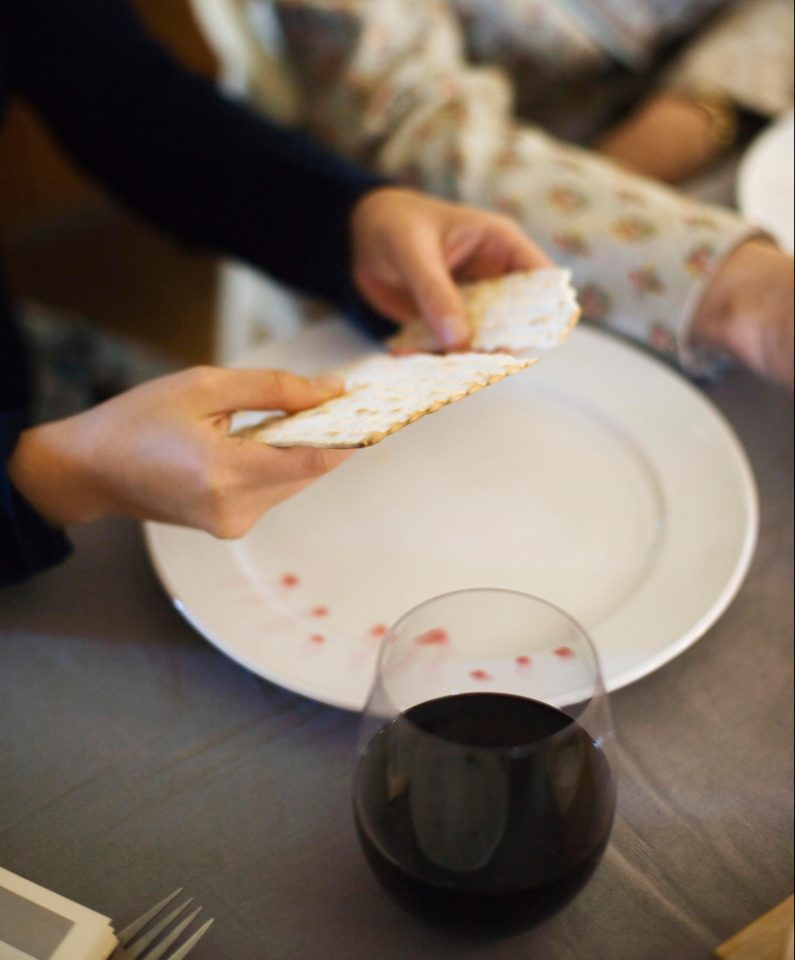  A woman breaks matzoh bread during the traditional Seder ritual