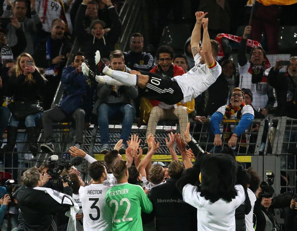  German hero Lukas Podolski is tossed into the air by his team-mates