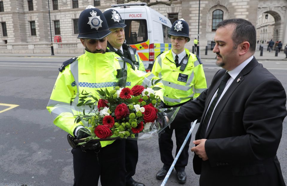  A police officer is given a floral tribute by a member of the public to lay as a tribute to PC Keith Palmer