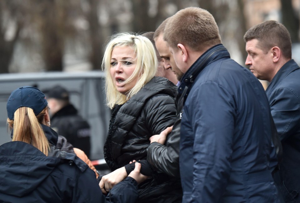 Maria Maksakova, wife of Denis Voronenkov, is led from the scene of her husband’s murder in Kiev