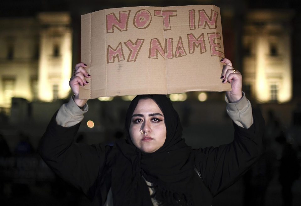  A woman holds a placard up during a candlelit vigil at Trafalgar Square