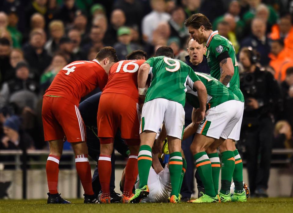  Players from both sides crowded round the stricken defender