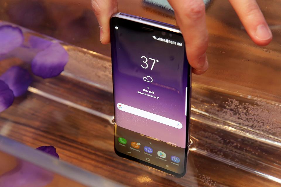  A Samsung Galaxy S8 mobile phone is shown partially submerged to demonstrate its water resistance