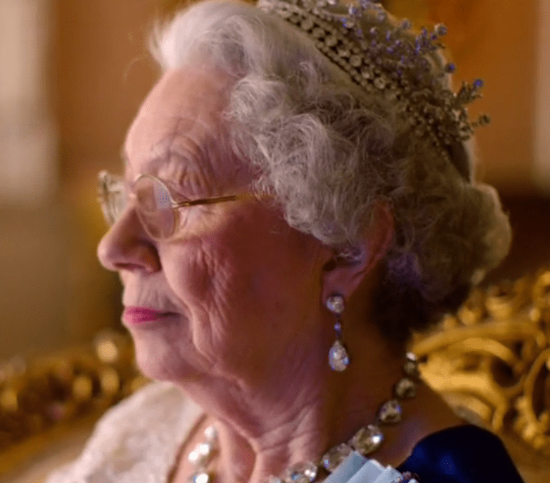  The Queen sitting in her finery watching reruns of the show