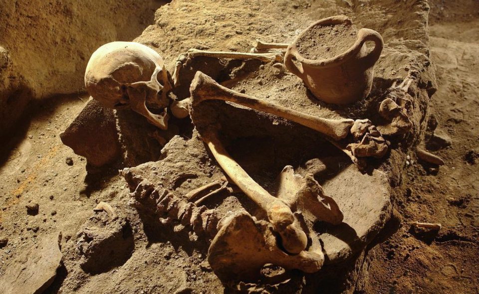  The remains of an ancient inhabitant of the city lie curled up on the ground next to a pot