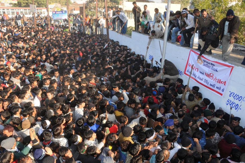 ndian policemen use batons to control the crowd of cricket fans jostling for tickets for the second Twenty20 cricket match between India and Pakistan in Ahmadabad, India, Wednesday, Dec. 26, 2012