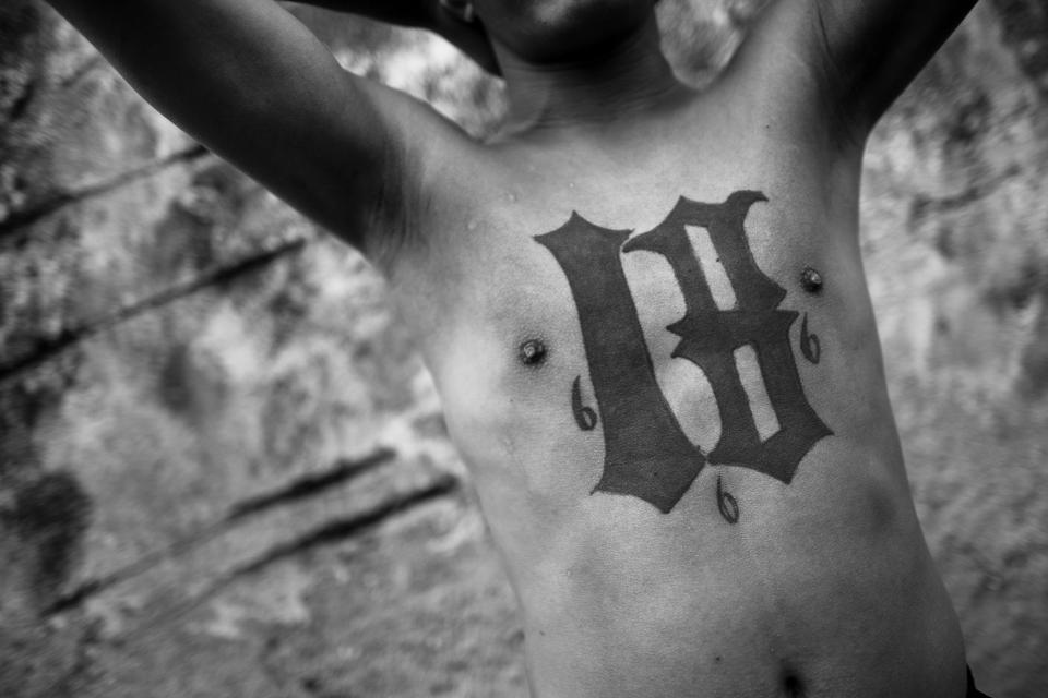  An 18th Street Gang (M-18) member shows off his tattoos